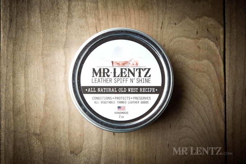 May include: A silver tin with a white label that reads "MR LENTZ LEATHER SPIFF N' SHINE &bull;ALL NATURAL OLD WEST RECIPE&bull; CONDITIONS PROTECTS PRESERVES ALL VEGETABLE TANNED LEATHER GOODS HANDMADE 2 oz"