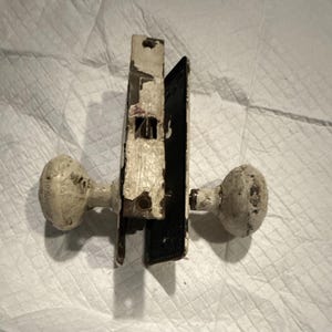 Set di pomelli per porte rotondi in metallo verniciato bianco vintage con placche di supporto e chiavistello.