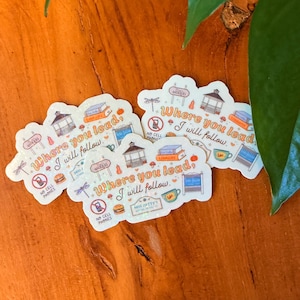 May include: A collection of holographic stickers with a whimsical design. Each sticker features the phrase "Where you lead, I will follow" along with illustrations of a gazebo, books, and other decorative elements. The stickers also include the text "No Cell Phones".