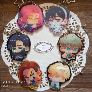 May include: A collection of anime-style acrylic charms, each featuring a unique character design with vibrant colors. The charms are approximately 2.5 inches in size and attached to keychains. The image includes text that reads "alnst charms 2.5".