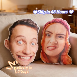May include: Two custom face pillows with expressive facial expressions. One pillow features a smiling man with wide eyes, the other a woman with a grimace. The pillows are on a beige couch.