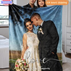 May include: A personalized blanket featuring a couple in wedding attire, with the word "love" and "Love You Forever" in script. The blanket has a blue and brown background. The image also shows two people holding the blanket. A "SALE" sticker is visible.