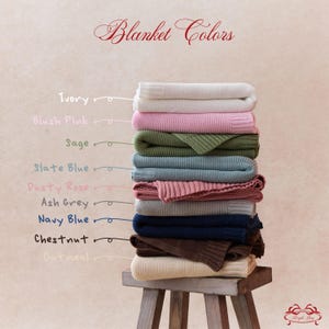 May include: A stack of folded knit blankets in various colors, including ivory, blush pink, sage, slate blue, dusty rose, ash grey, navy blue, chestnut, and oatmeal. The text "Blanket Colors" is displayed at the top.