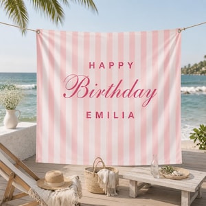 K&ouml;nnte beinhalten: Ein rechteckiger Stoffhintergrund mit vertikalen hellrosa und wei&szlig;en Streifen. Der Text "HAPPY" erscheint in einer fetten serifenlosen Schrift &uuml;ber dem Wort "Birthday" in Schreibschrift und dem Namen "EMILIA" in fetter serifenloser Schrift, alles in Rosa.