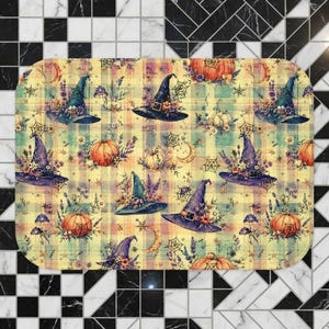 Puede incluir: Una alfombrilla de baño rectangular con un patrón repetitivo de sombreros de bruja, calabazas naranjas, lunas crecientes, telarañas y detalles florales sobre un fondo de cuadros amarillos, verdes y naranjas con esquinas redondeadas.