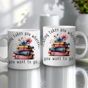 Puede incluir: Dos tazas de cerámica blancas con el texto "reading takes you wherever you want to go." Cada taza presenta una pila de libros con cubiertas rosas, azules y amarillas, coronada con flores. Las tazas tienen asas blancas.