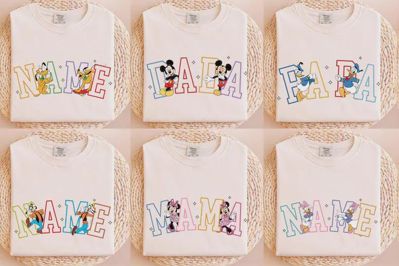 K&ouml;nnte beinhalten: Wei&szlig;e T-Shirts mit verschiedenen Disney-Charakter-Designs. Jedes Shirt hat ein anderes Design, darunter Charaktere wie Mickey Mouse, Donald Duck und Pluto, mit Texten wie "NAME", "DADA" und "MAMA" in farbenfrohen Buchstaben.