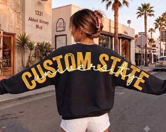 Sudadera Comfort Colors® personalizada para equipo universitario, top deportivo personalizado con estampado grande en la espalda y efecto desgastado, camiseta con texto grande y llamativo de hombro a hombro.