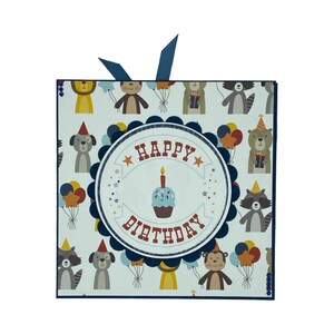 May include: A blue and white birthday card with a blue ribbon. The card has a pattern of animals and balloons. The front of the card says "Happy Birthday" with a cupcake and candle.
