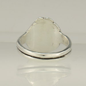 May include: A silver ring with a smooth, oval-shaped top. The ring is made of sterling silver and has a simple, elegant design.
