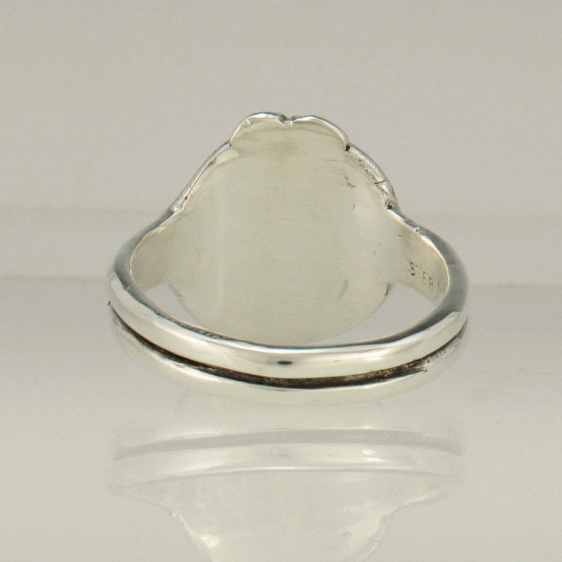 May include: A silver ring with a smooth, oval-shaped top. The ring is made of sterling silver and has a simple, elegant design.