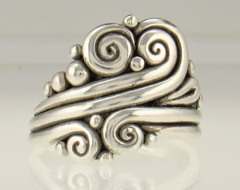 May include: A silver ring with a swirling wave design. The ring is made of sterling silver and has a textured finish.