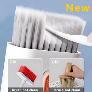 Könnte beinhalten: Eine weiße Reinigungsbürste mit einem großen, dichten Borstenkopf. Das Wort "New" wird in Gelb angezeigt. Das Bild zeigt auch zwei kleinere Bilder von alten Bürsten, eine rote und eine mit Holzgriff, mit dem Text "brush not clean".