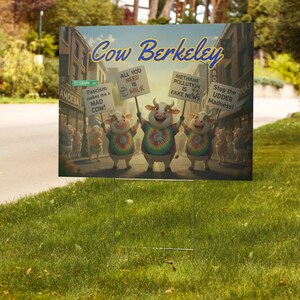 May include: A yard sign featuring a cartoon image of cows protesting with signs that read "All You Need Is Milk", "Methane Pollution Is Fake News", and "Stop the Udder Madness!". The sign also has the text "Cow Berkeley".