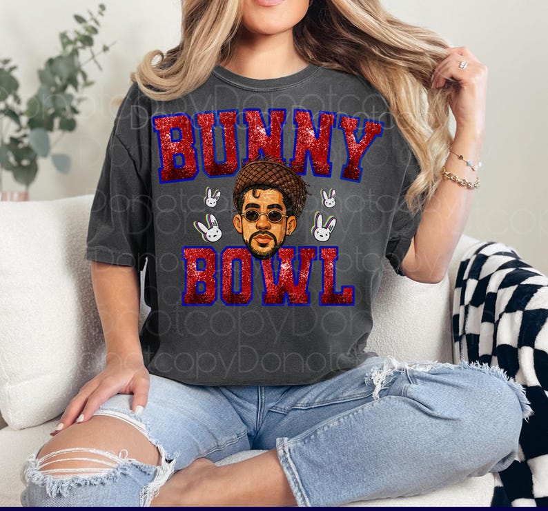 May include: Dark gray t-shirt with the text "BUNNY BOWL" in red glitter letters with a blue outline. The shirt features a graphic of a man wearing sunglasses and a hat, surrounded by white bunny faces.