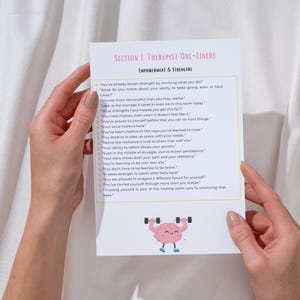 May include: A white paper with text titled "SECTION 1: THERAPIST ONE-LINERS" and "EMPOWERMENT & STRENGTHS". The paper has a cartoon brain lifting weights. The paper is held by two hands.