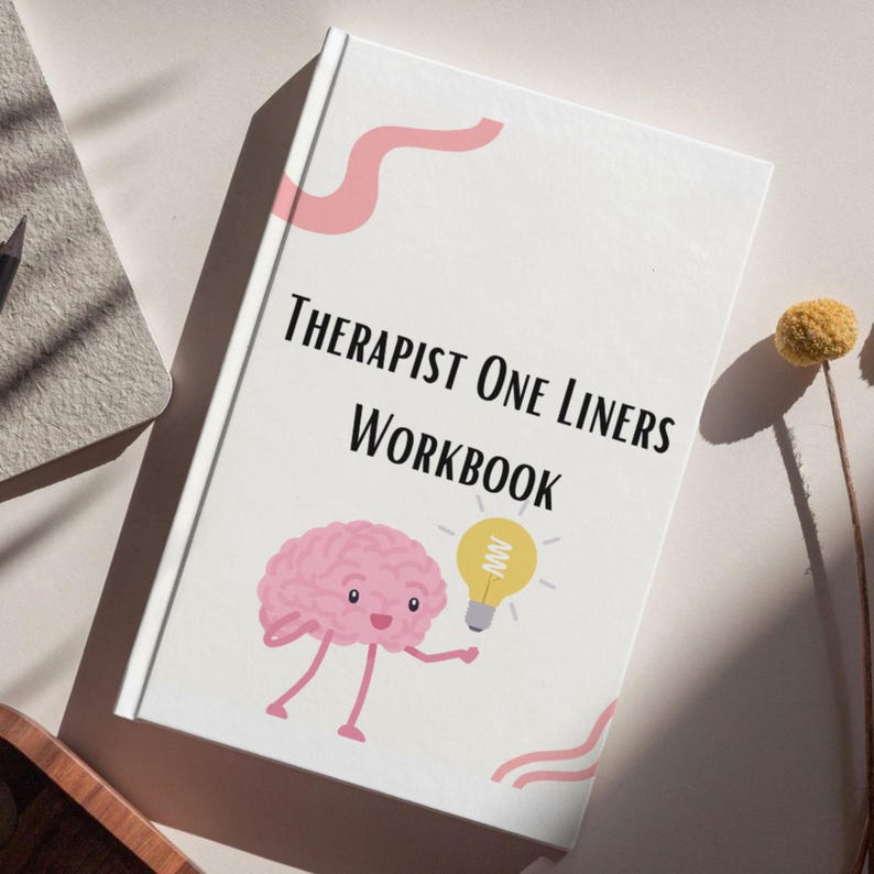 May include: A white workbook titled "Therapist One Liners Workbook" with a pink brain character holding a yellow lightbulb. The cover has pink decorative lines. The workbook is on a light-colored surface.