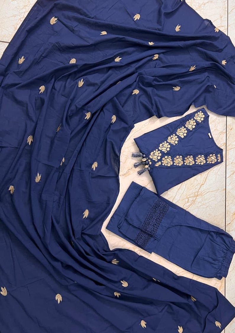 May include: A navy blue three-piece outfit featuring a long, flowing scarf, a sleeveless top, and pants. The top and pants have gold floral embroidery. The scarf is scattered with gold leaf-shaped embroidery. The pants have a decorative lace trim.