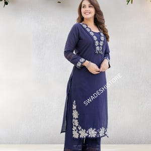 May include: A navy blue embroidered kurta and palazzo set. The long-sleeved kurta features white floral embroidery along the neckline, cuffs, and side slit. The palazzo pants have matching embroidery at the hem. The text "SWADESHI STORE" is visible.