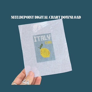 Puede incluir: Un lienzo de punto de aguja con un diseño de limón amarillo y la palabra "ITALY". El texto "NEELDPOINT DIGITAL CHART DOWNLOAD" está en la parte superior. El lienzo es sostenido por una mano.