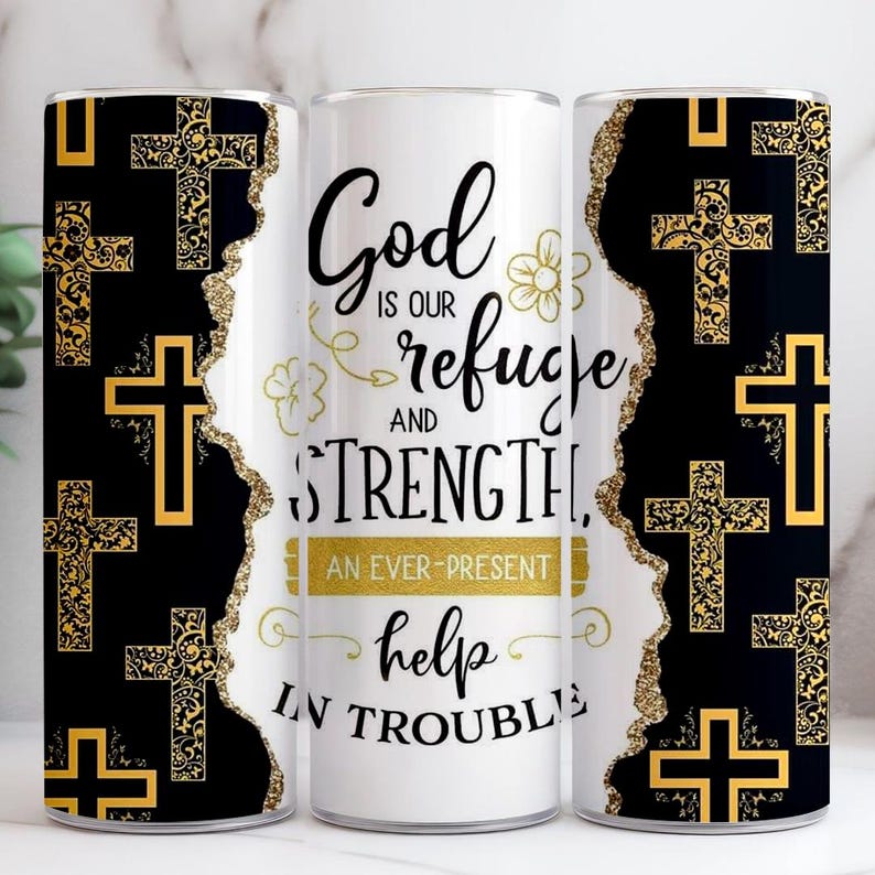 May include: A white tumbler featuring the text "God is our refuge and strength, an ever-present help in trouble." The sides of the tumbler have a black and gold cross pattern.