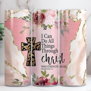 May include: A stainless steel tumbler with a pink and gold design, featuring a cross with a leopard print pattern. The tumbler has the text "I Can Do All Things Through Christ" and floral accents.