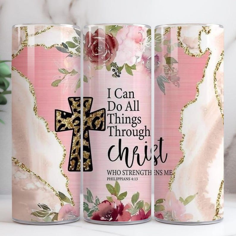 May include: A stainless steel tumbler with a pink and gold design, featuring a cross with a leopard print pattern. The tumbler has the text "I Can Do All Things Through Christ" and floral accents.