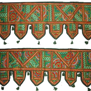 Puede incluir: Dos cenefas textiles bordadas en verde y rojo con patrones geométricos y florales. Cada cenefa tiene un borde verde oscuro, borlas decorativas y detalles de espejo. El diseño presenta triángulos, círculos y costuras intrincadas.