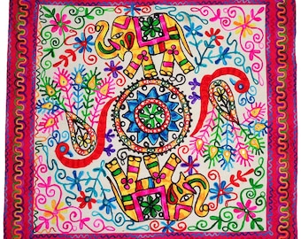May include: Square, off-white textile with colorful embroidery. Features two yellow elephants, a central mandala, and floral and paisley motifs. The border is a wavy, magenta design. The embroidery includes pink, blue, green, and yellow.