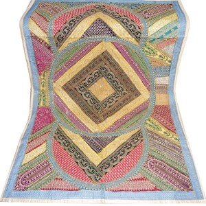 Könnte beinhalten: Ein farbenfrohes Patchwork-Textil mit einem zentralen Rautenmuster. Das Textil weist eine Vielzahl von Mustern und Farben auf, darunter Rosa, Gelb, Grün und Blau. Die Ränder sind mit einem hellblauen Rand versehen.