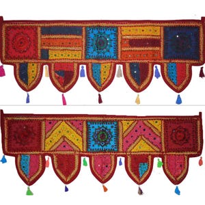 Op de afbeelding: Twee kleurrijke, handgemaakte textiele valletjes. Elk heeft een patchwork-ontwerp met rode, blauwe, gele en roze vierkanten, versierd met spiegels en kwastjes. De valletjes zijn waarschijnlijk voor woondecoratie.