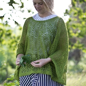 Könnte beinhalten: Eine Frau trägt einen grünen Häkelpullover und einen schwarz-weiß gestreiften Rock. Sie hält ein grünes Blatt in der Hand.