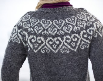 May include: A gray knitted sweater with a white geometric pattern. The sweater has a crew neck and long sleeves.
