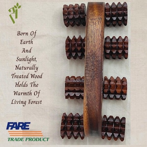 May include: A wooden massage roller with a central handle and four textured rollers. The wood is a rich brown color. The image includes text that reads "Born Of Earth And Sunlight, Naturally Treated Wood Holds The Warmth Of Living Forest" and "FARE TRADE PRODUCT."