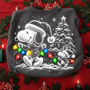 May include: A dark grey crewneck sweatshirt featuring a graphic of Snoopy and Woodstock wearing Santa hats and scarves. They are walking through snow, carrying a string of colourful glowing Christmas lights near a decorated pine tree and gifts.