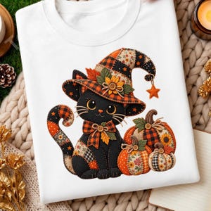 May include: A white t-shirt featuring a graphic of a black cat wearing a patchwork witch hat and a matching bow tie. The cat is sitting next to two pumpkins decorated with orange, black, and floral patchwork patterns and small buttons.