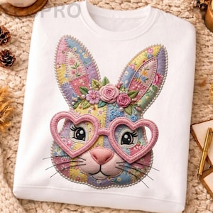 Op de afbeelding: Witte sweatshirt met een kleurrijk patchwork konijnengezicht, hartvormige bril en een bloemenkrans. Het ontwerp bevat parelaccenten. Een grillig en gedetailleerd ontwerp, ideaal voor Pasen of de lente.