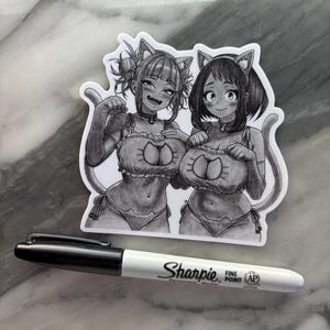 Puede incluir: Adhesivo en blanco y negro con dos personajes femeninos de estilo anime con orejas y colas de gato, vestidas con lencer&iacute;a. Un rotulador Sharpie de punta fina en blanco y negro est&aacute; al lado de la pegatina.