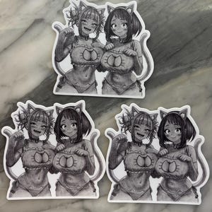 Puede incluir: Un conjunto de pegatinas de estilo anime con dos personajes femeninos con trajes con tem&aacute;tica de gatos. Las ilustraciones en blanco y negro representan a los personajes en trajes de ba&ntilde;o con orejas y colas de gato. Las pegatinas est&aacute;n sobre un fondo blanco.