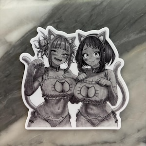 Puede incluir: Una pegatina en blanco y negro con dos personajes de estilo anime vestidos con trajes con tem&aacute;tica de gatos. Los personajes sonr&iacute;en y llevan orejas de gato. La pegatina est&aacute; sobre un fondo blanco.