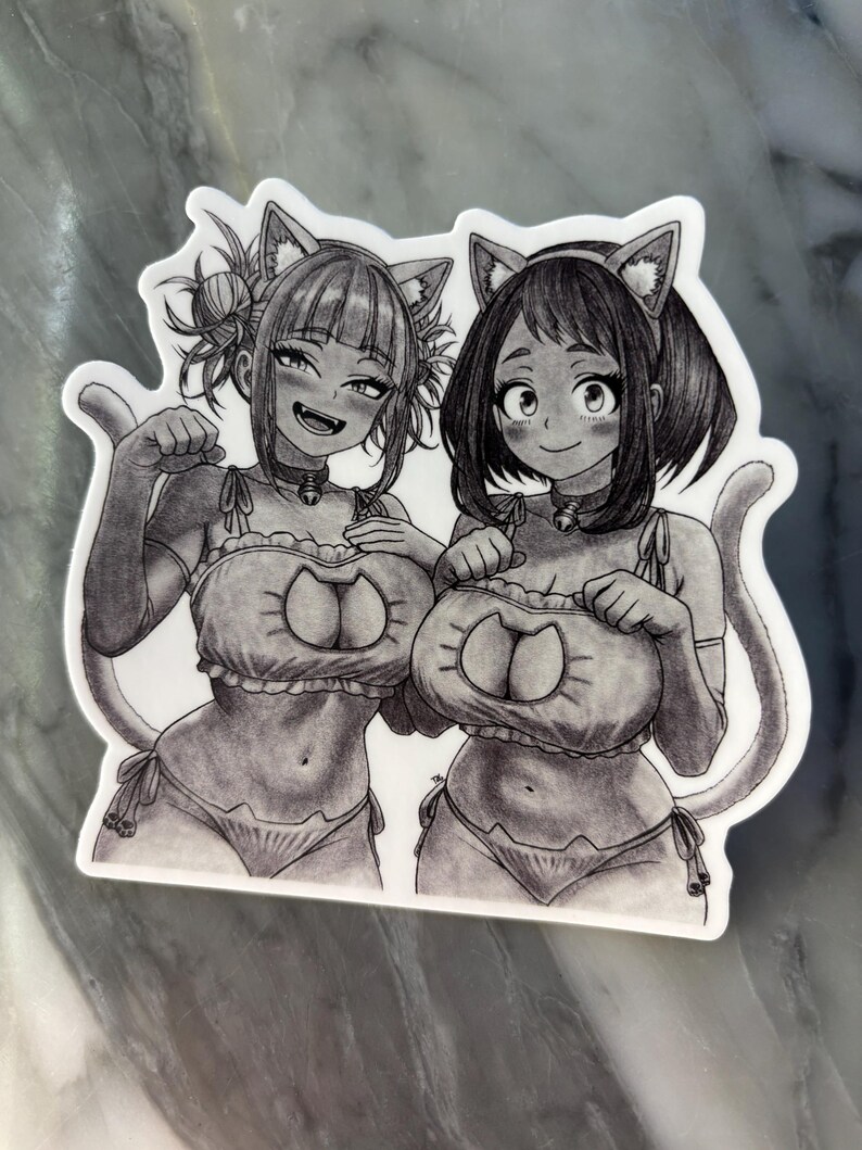 Puede incluir: Una pegatina en blanco y negro con dos personajes de estilo anime vestidos con trajes de gato. Los personajes sonr&iacute;en y llevan orejas y colas de gato. La pegatina tiene un borde blanco.