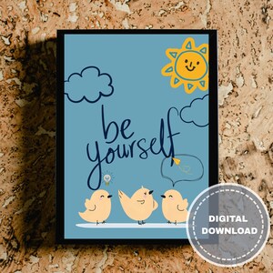 May include: A framed art print with a light blue background featuring the words "be yourself" in cursive. The print includes cartoon illustrations of yellow birds, clouds, and a smiling sun. A digital download sticker is in the bottom right corner.
