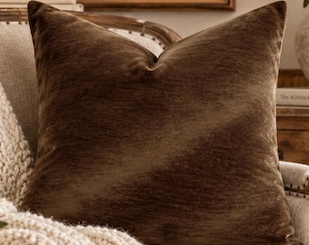 May include: A square cocoa brown velvet pillow cover featuring a hidden zipper. The text on the right side reads: Simply Posh Pillows, Cocoa Velvet, Pillow Cover Only, Hidden Zipper, Made in USA, BEAUTIFUL SPACES A HAPPIER YOU.