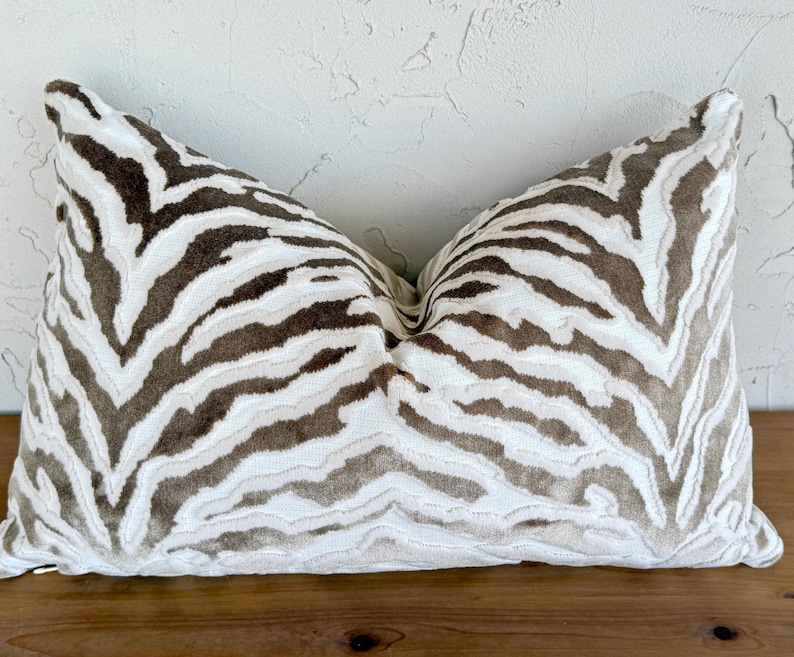 May include: A white and brown zebra patterned throw pillow with a soft, plush texture.
