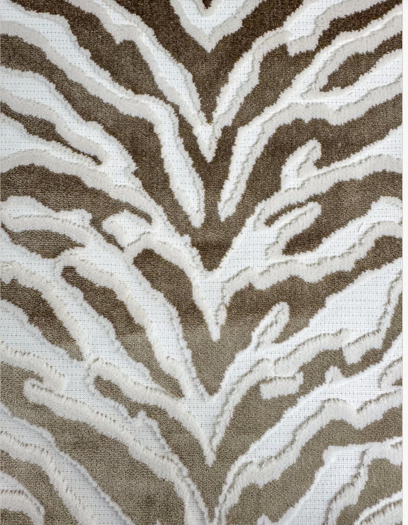 May include: A white and brown zebra print rug with a textured, fluffy surface.