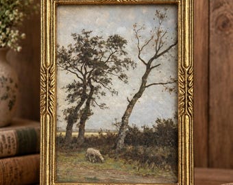 May include: A rectangular painting in an ornate gold frame featuring a landscape scene with two prominent trees, a light blue sky, and a small sheep grazing in a grassy field. The frame has detailed carved patterns along its edges.