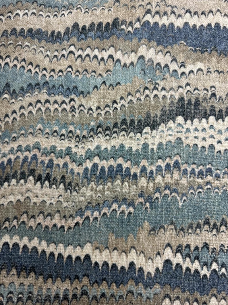 May include: A close-up of a fabric with a wavy pattern in shades of blue, brown, and white.