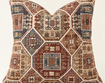 May include: A square throw pillow featuring a geometric pattern of interlocking octagons and squares. The fabric displays a multi-colored design in shades of rust red, deep blue, and beige, with intricate, symmetrical motifs within each shape.