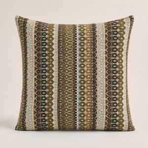 May include: A square throw pillow featuring a vertical striped pattern in shades of olive green, dark brown, tan, and cream. The fabric has a textured, woven appearance with repeating geometric motifs and thin lines running across the entire surface.