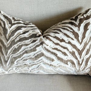 May include: A brown and white zebra patterned throw pillow with a soft, plush texture.